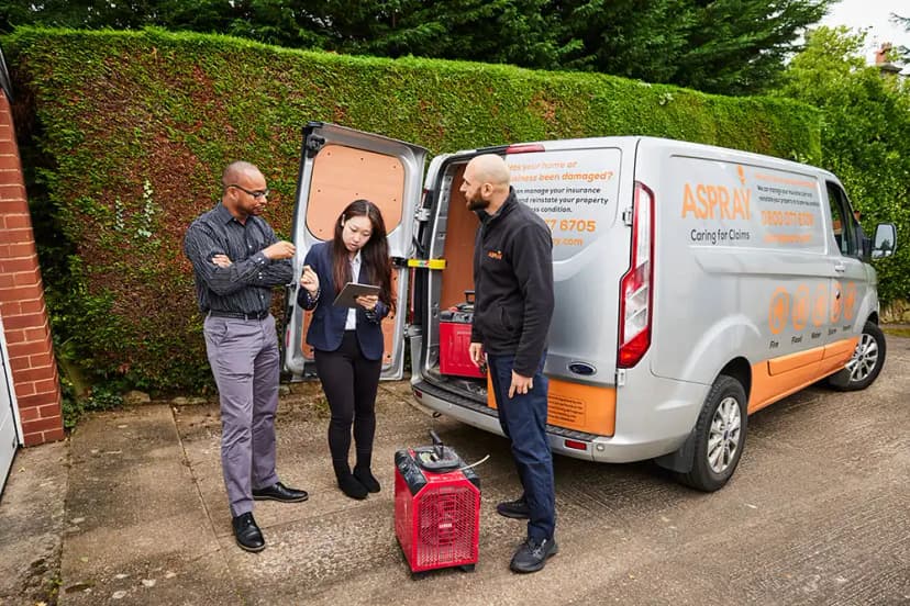 Aspray franchise team managing a property insurance claim on-site with branded van