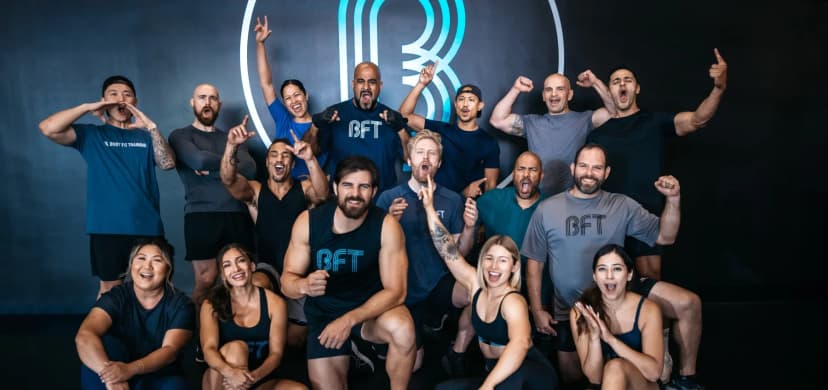 BFT Body Fit Training members and coaches celebrating together inside a studio